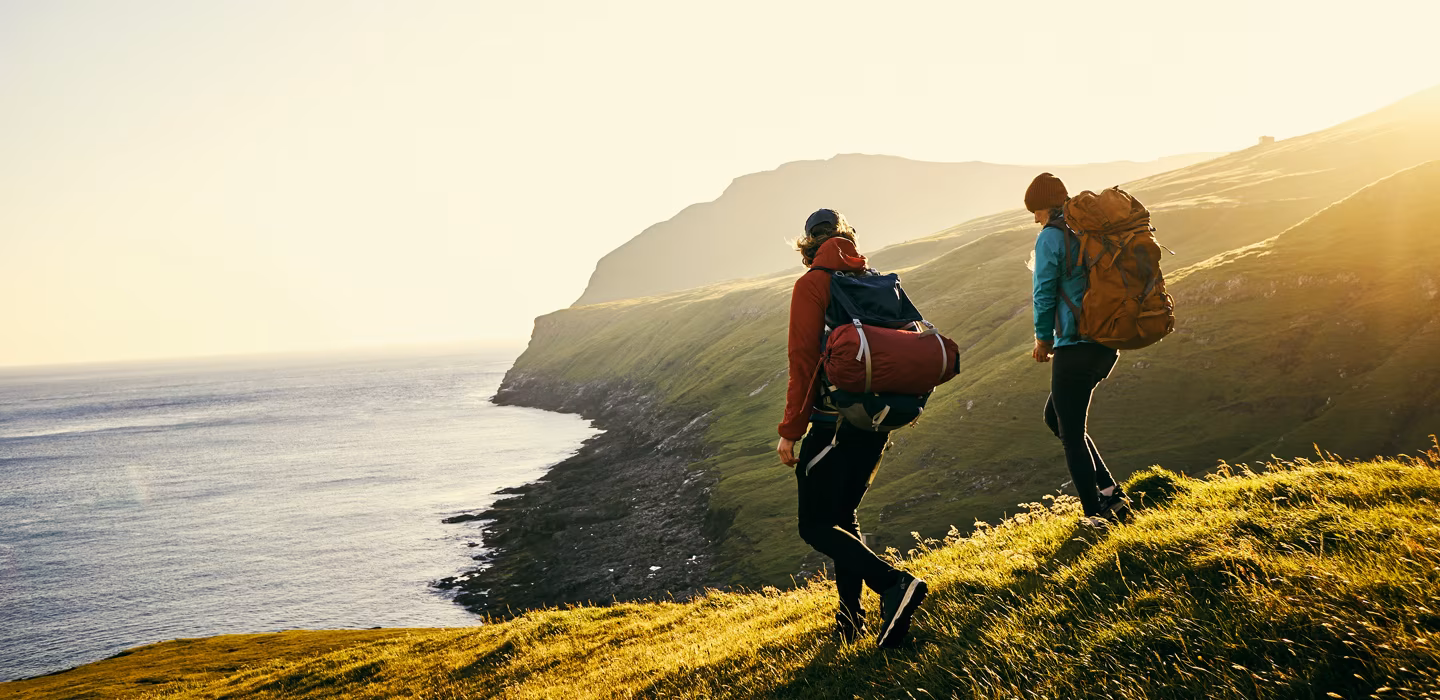 Two investors walking among sunlit hills
