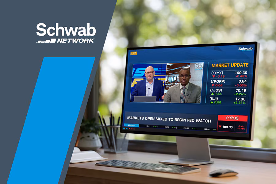 A computer monitor shows Schwab Network's live stream.